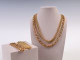 deux bijoux exposés sur une surface blanche
