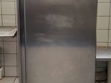 a stainless steel refrigerator in a kitchen with tile flooring