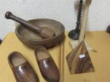 a table with a bowl, a pair of wooden shoes and a pair of wooden spoons on it