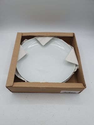 une assiette blanche dans une boîte posée sur une surface blanche
