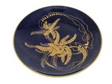 une assiette bleue ornée d'un motif doré
