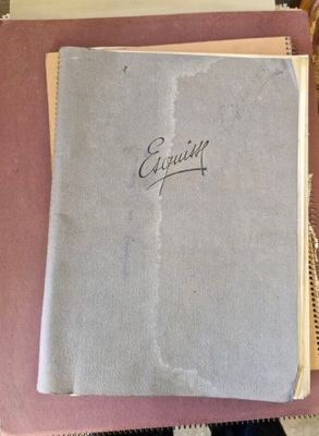 un vieux livre posé sur une table, à côté d'un verre de vin