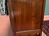 a wooden cabinet with a marble top on a rug