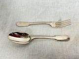 two spoons and a fork sitting on a table