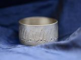 a close up of a silver ring on a blue cloth