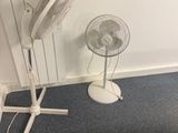 un ventilateur blanc posé à côté d'un ventilateur de table blanc