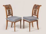 deux chaises en bois avec des coussins d'assise à motifs, sur fond blanc