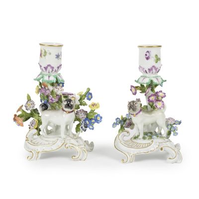 deux vases blancs ornés de fleurs, posés sur une table
