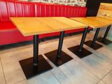 tables and benches in a restaurant with red booths