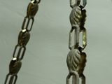 a close up of a metal chain with beads on it