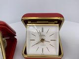 two clocks sitting next to each other on a table