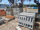 a pile of cinder blocks on the ground next to a tree