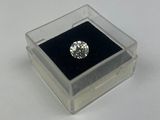 un diamant dans une boîte transparente posée sur une surface blanche