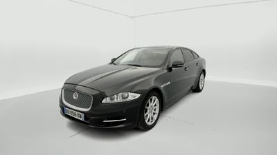 un jaguar noir garé dans une pièce blanche sur fond blanc