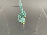 a small figurine of a bird sitting on top of a clear box
