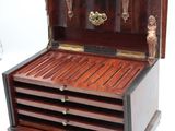 a small wooden box with three drawers on it