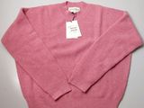 the sweater is pink and has a white tag on it
