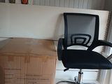 a black office chair sitting next to a stack of boxes