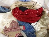 a pile of clothes that is sitting on a bed