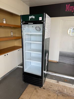 un réfrigérateur au milieu d'une pièce équipée d'étagères
