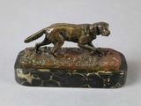 statue of a dog running on a marble base on a white surface