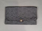 an old black purse with writing on it sitting on a table