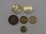 several different coins are arranged on a white surface