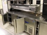 une cuisine avec de nombreux plans de travail et appareils électroménagers en inox