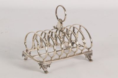 a silver plated toaster that has a bunch of toasting utensils on it