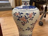 un vase posé par terre devant une chaise