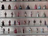 de nombreuses figurines exposées sur des étagères en verre dans une vitrine