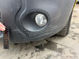 a person measuring the front bumper of a car