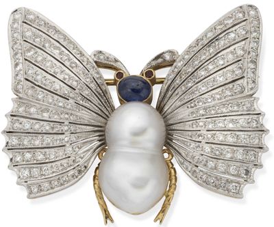 a close up of a white pearl and diamond insect broochle