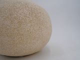 a white stone ball sitting on a white surface