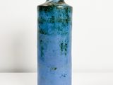 un vase bleu posé sur une table blanche