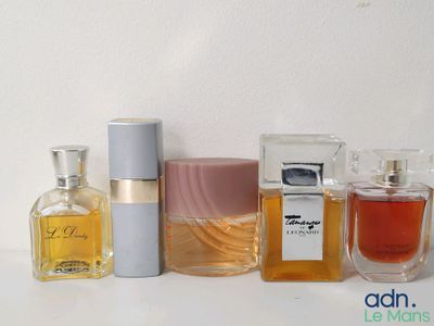 de nombreux parfums différents posés sur une table blanche