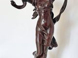 bronze statue of a woman holding a flower and a bird in her hand