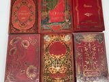 six red books sitting on top of each other on a table