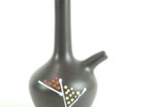 a black vase with an orange and white design on it