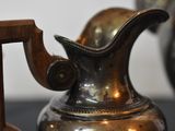 a silver vase with a wooden handle on a table