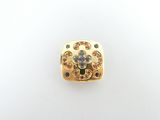 a close up of a gold plated metal object with blue and white stones