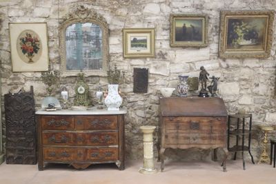 de nombreux tableaux accrochés au mur au-dessus des commodes dans cette pièce