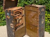 two old suitcases sitting on the ground next to a brick wall