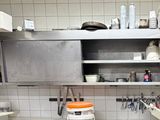 une cuisine équipée d'une cuisinière, d'un évier et de placards