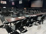 tables and chairs in a conference room with a projector screen