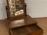 a small wooden dresser with a mirror on top of it