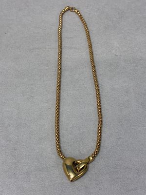 a gold necklace with a heart shaped pendant on it