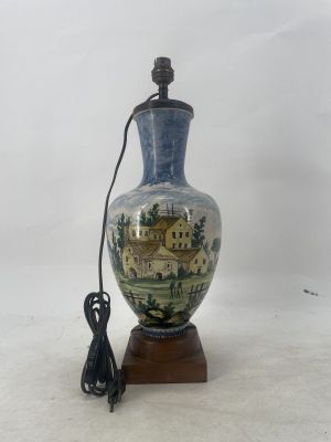 a blue and white vase on a wooden stand with a power cord