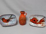 trois assiettes et un vase posés sur une table