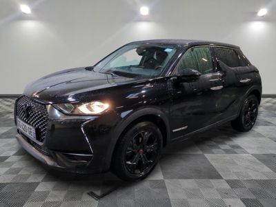 un 4x4 noir garé sur un sol en damier dans un garage